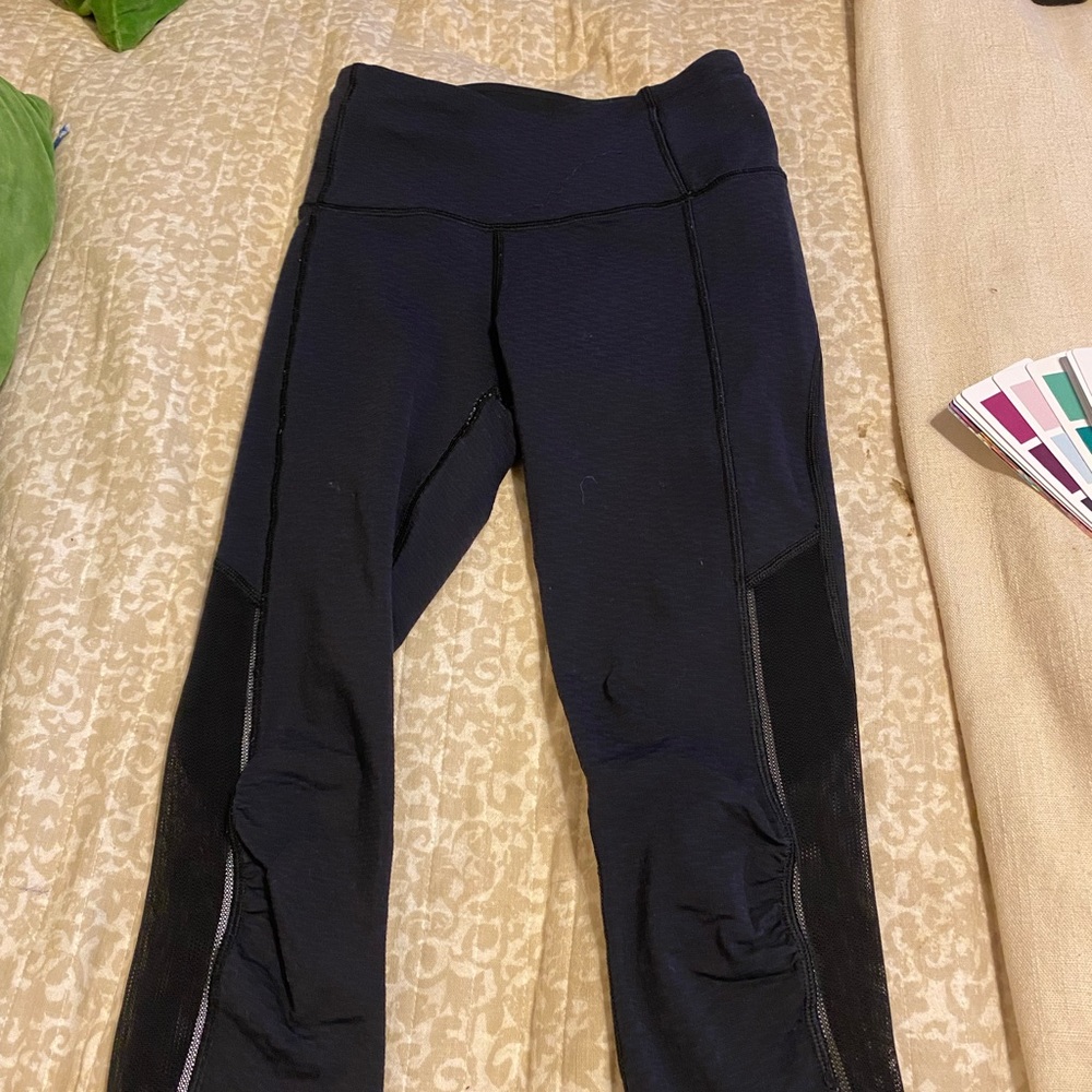 Lululemon size two capri leggings. Navy blue with mesh around bottom.